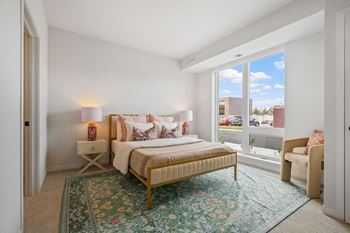 a bedroom with a bed and a large window